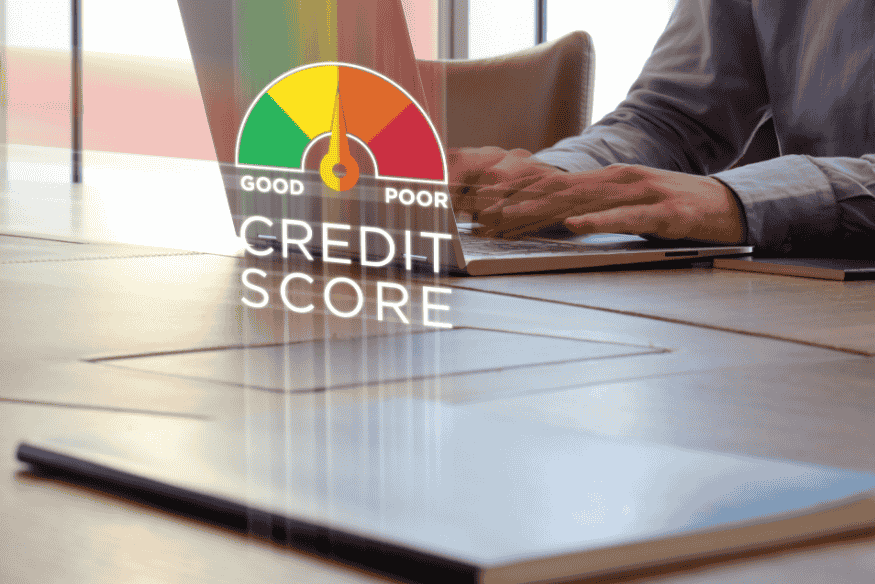 Person working on a laptop with a credit score gauge showing the impact of debt management.