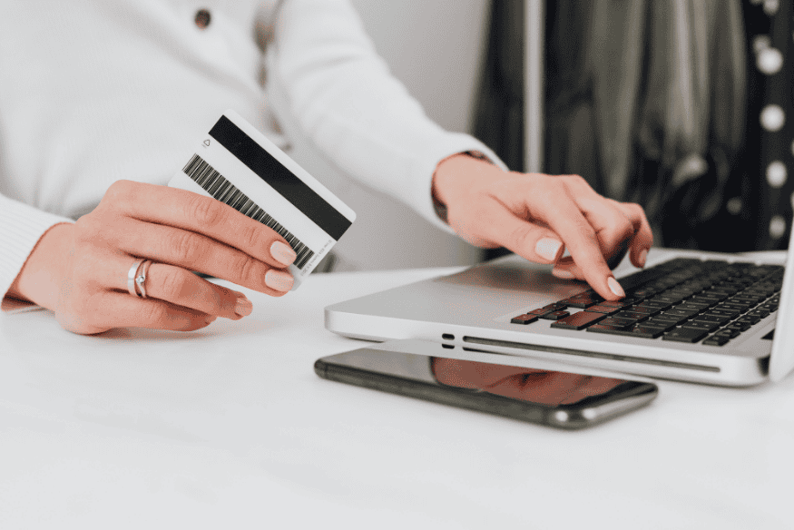 Woman making an online payment with a credit card on her laptop to build a better credit score.