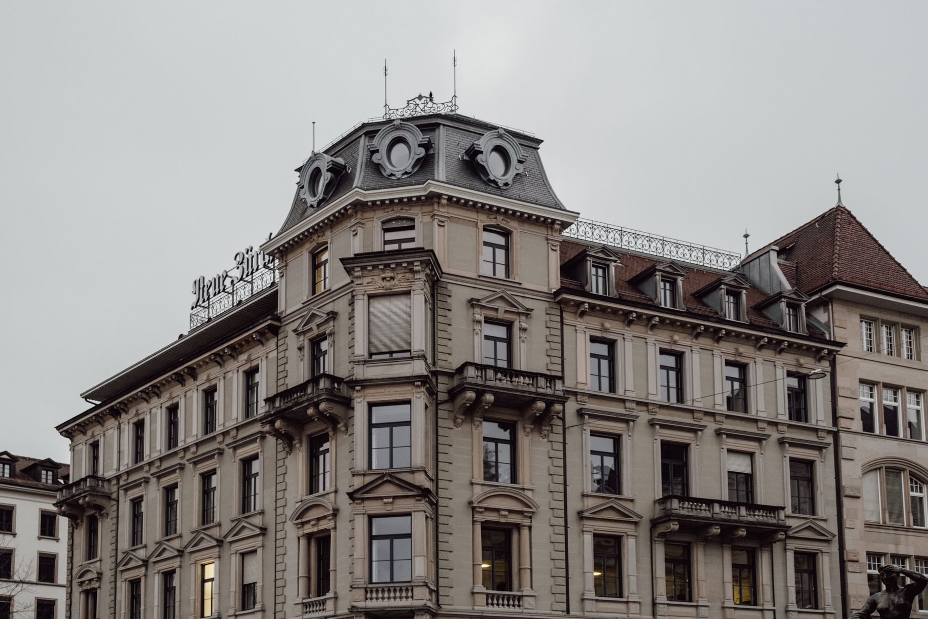 View of a neoclassical building in Zurich, showcasing urban architecture on a cloudy day.