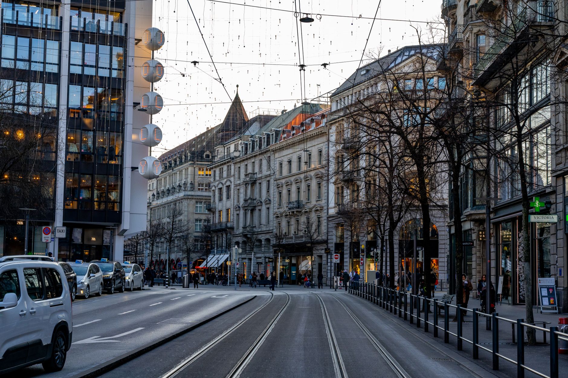 Street view of Bahnhofstrasse, Zürich during twilight with city lights and architectural buildings.