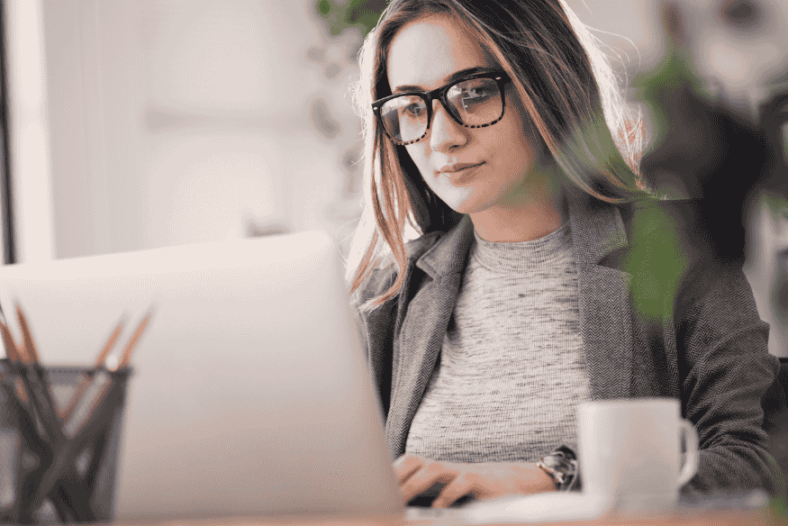 Woman working on a laptop while planning side income strategies for financial stability.