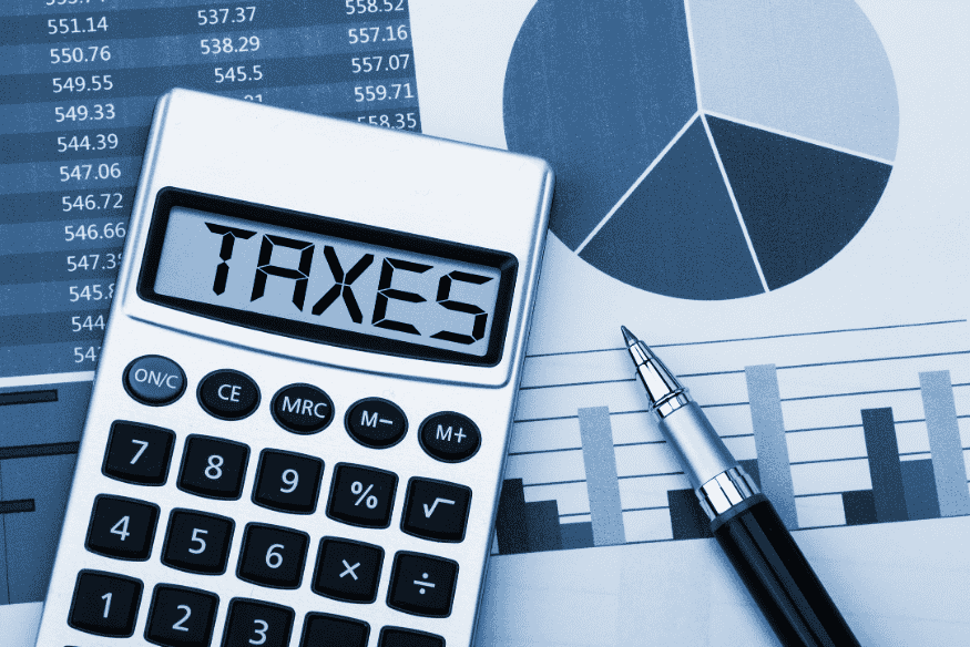 Calculator showing the word taxes on financial reports for freelancers and self-employed individuals
