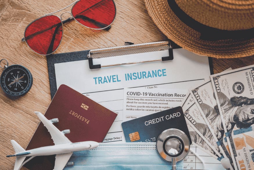 Itens de viagem como passaporte, cartão, dinheiro e seguro dispostos em uma mesa