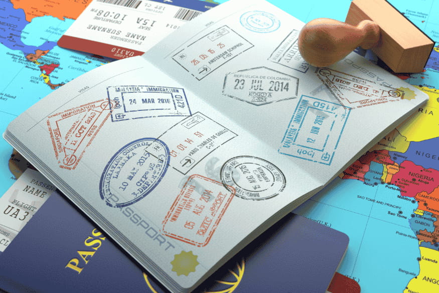 Passaporte aberto com vários carimbos sobre mapa-múndi