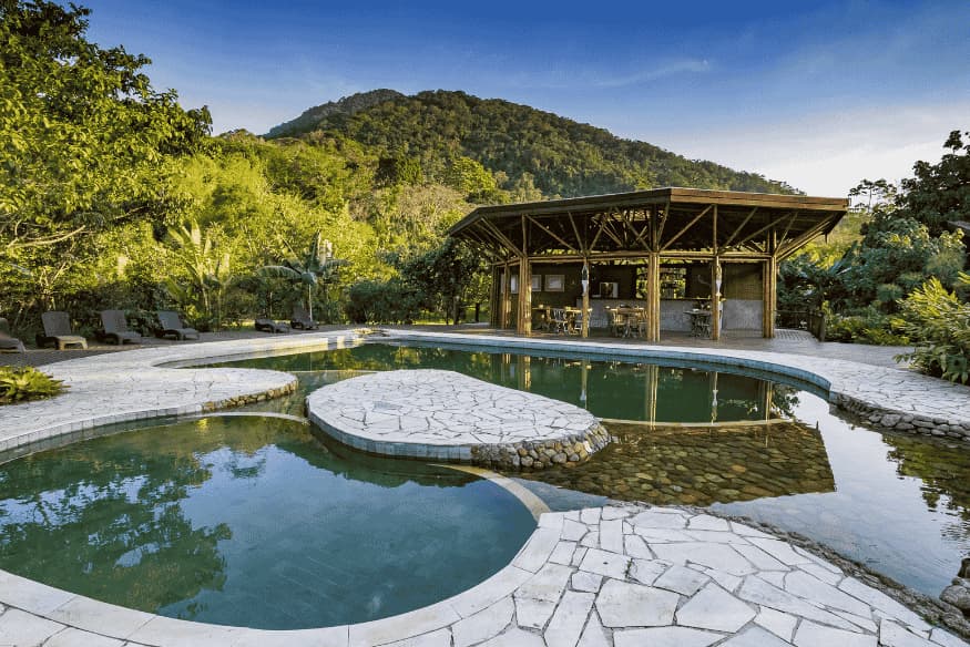 Piscina ecológica e estrutura em madeira do Banana Bamboo Ecolodge em meio à Mata Atlântica