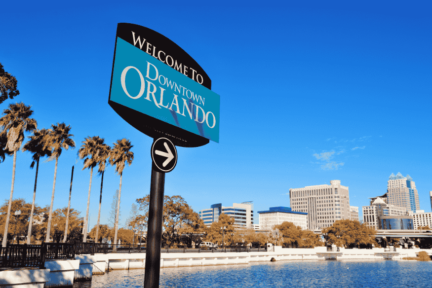 Placa “Welcome to Downtown Orlando” com prédios ao fundo