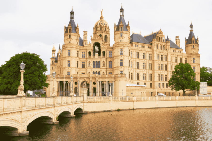 Vista frontal do Castelo de Schwerin com ponte sobre lago na Alemanha.