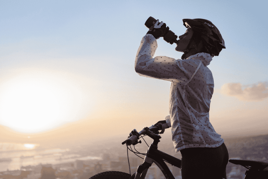 Ciclista hidratando-se durante pedalada na Estrada Real ao amanhecer