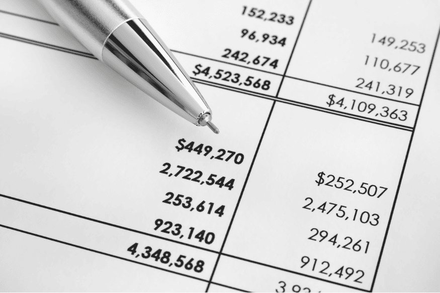 Close up of financial statement with pen, used to analyze fees, interest rates and spending before picking a credit card.