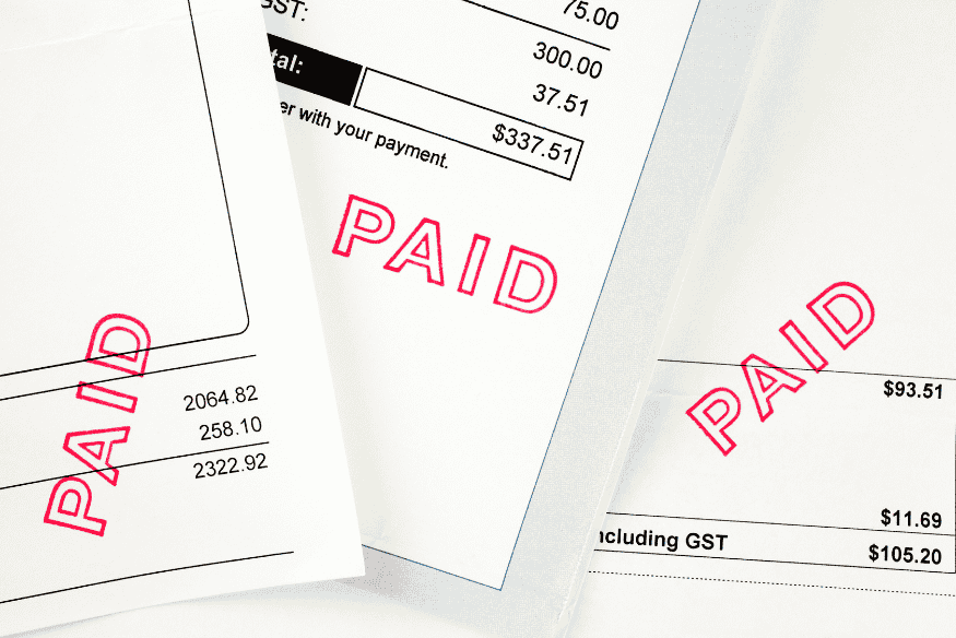 Stack of bills stamped “PAID” in red ink.