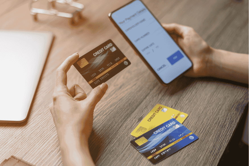 Person choosing between several credit cards while making an online payment on a smartphone
