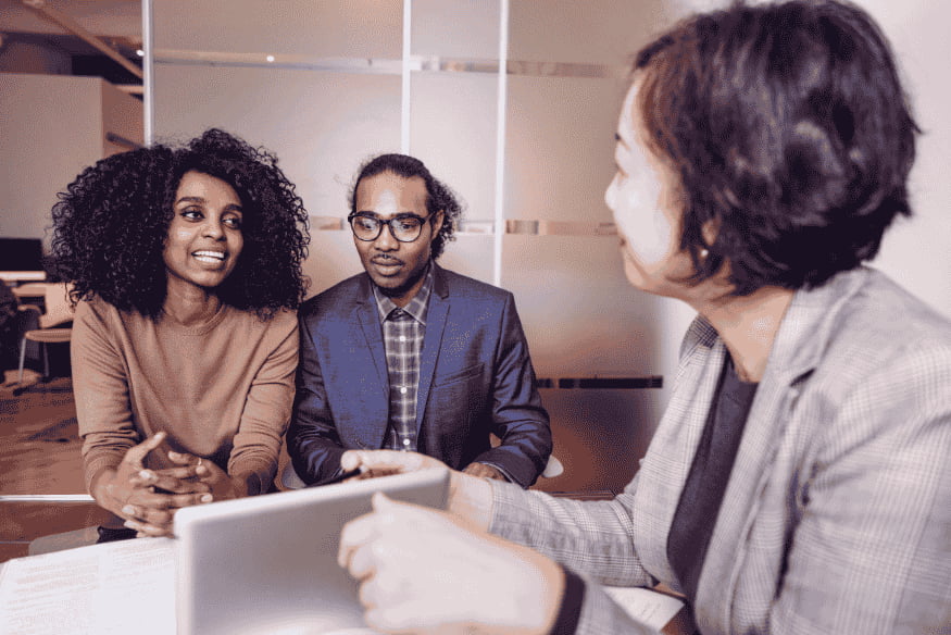 Couple meeting with a financial advisor to learn how to use a credit card responsibly to improve their credit score.