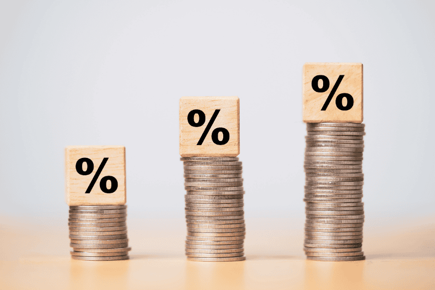 Three rising stacks of coins with percentage symbols showing growth in financial surplus over time