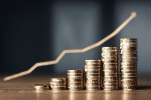 Stacks of coins increasing in height with an upward line graph representing personal break-even point and financial growth