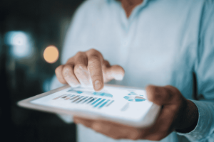 Person reviewing personal finance KPI dashboard with charts on a tablet