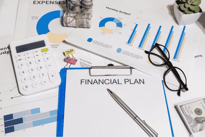 Financial plan document with calculator, charts and cash illustrating personal financial planning for beginners