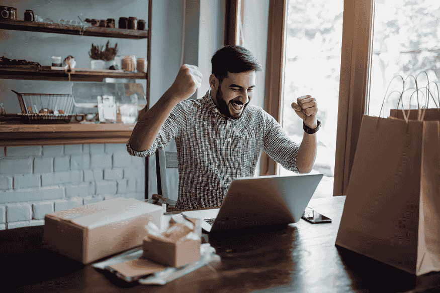 Happy entrepreneur celebrating online sales while using the Profit First method to manage cash and profit