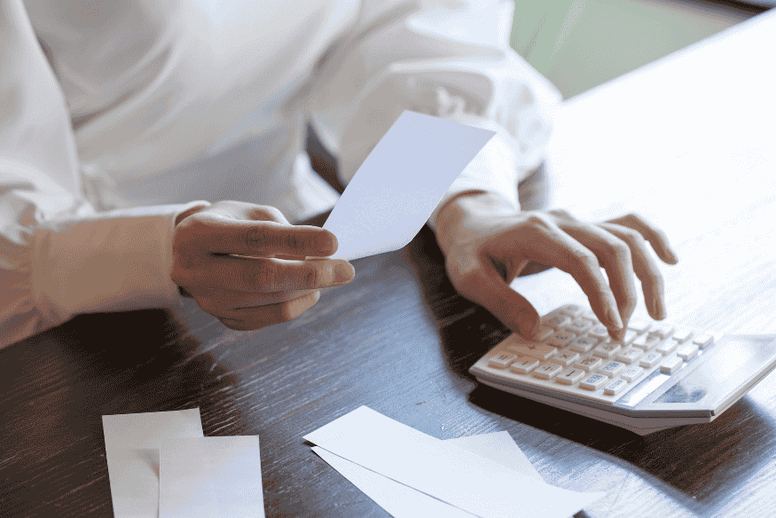 Person checking receipts and using a calculator to separate personal and work expenses