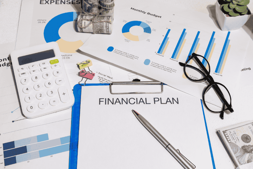Financial plan clipboard with charts, calculator and money for organizing a step-by-step personal financial plan