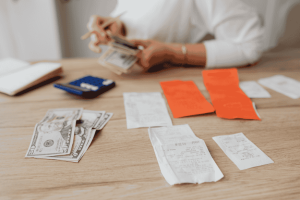 Person reviewing receipts and counting cash as the first step of personal financial planning