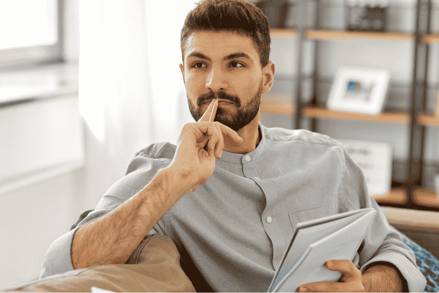 Thoughtful man holding documents while comparing payment options for budgeting, Buy Now Pay Later, and credit card use